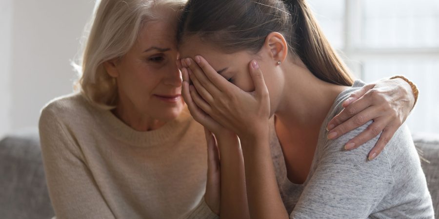 Woman comforts young woman who is suicidal